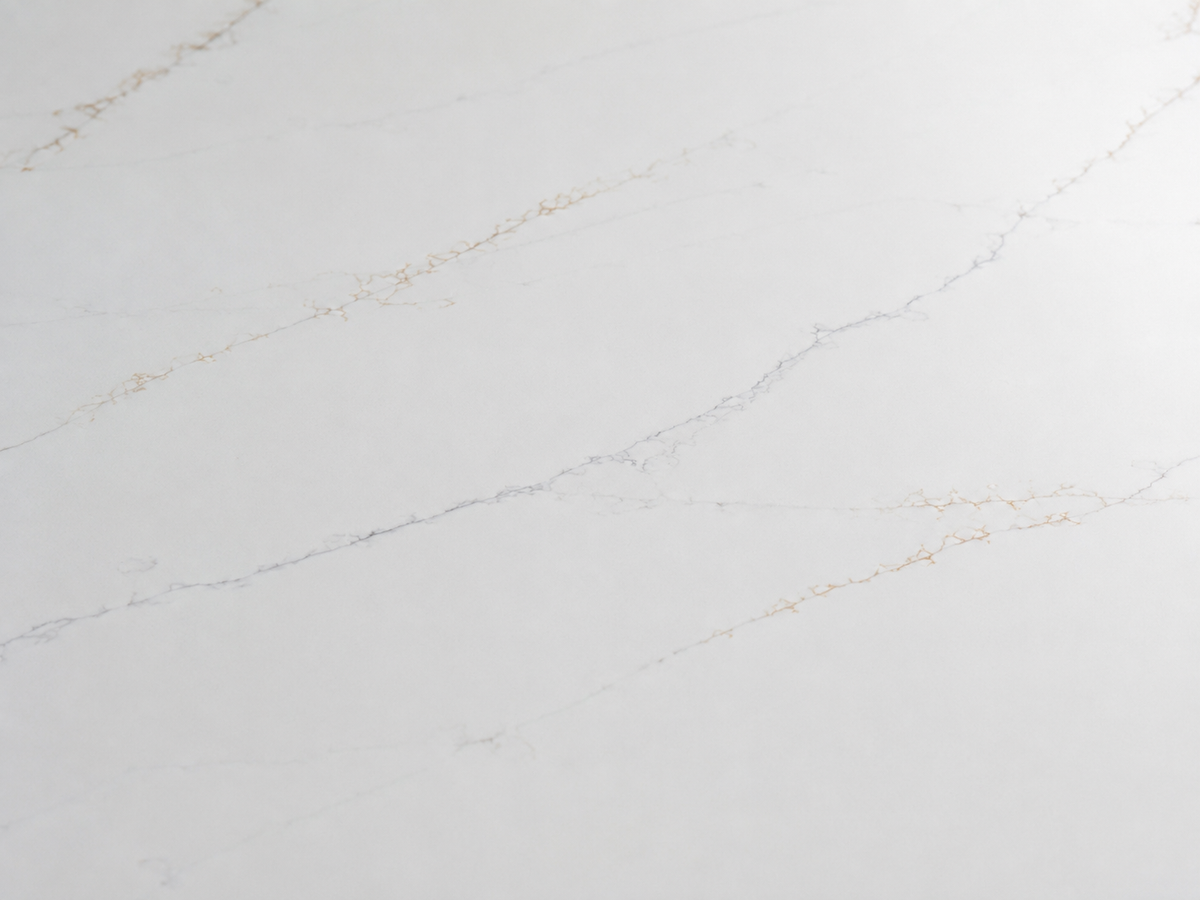 Close-up of polished Lumina Gold Quartz showing delicate cool-gray and champagne-gold branching lines