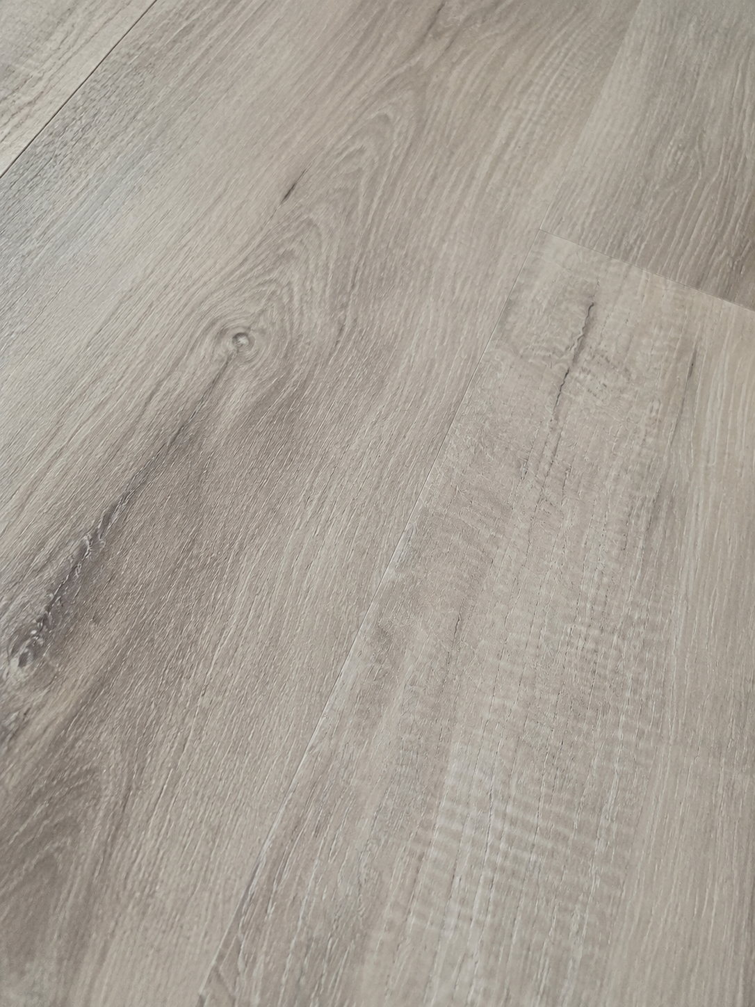 Close-up of Coastal Breeze SPC flooring grain and low-sheen texture